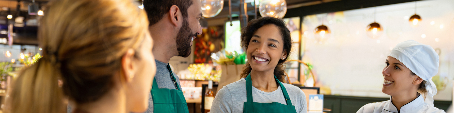 Funcionários de um café ou restaurante atendendo clientes com sorriso, criando um atendimento amigável e eficiente, ambiente acolhedor e profissional.